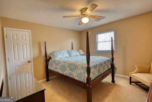 bedroom featuring a textured ceiling, baseboards, and light colored carpet