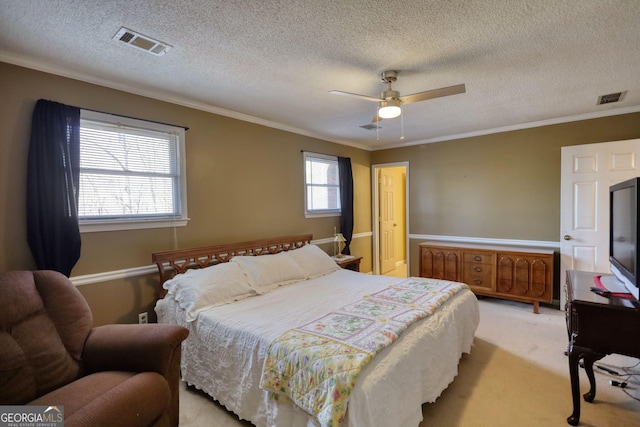 bedroom with light carpet, ceiling fan, visible vents, and crown molding