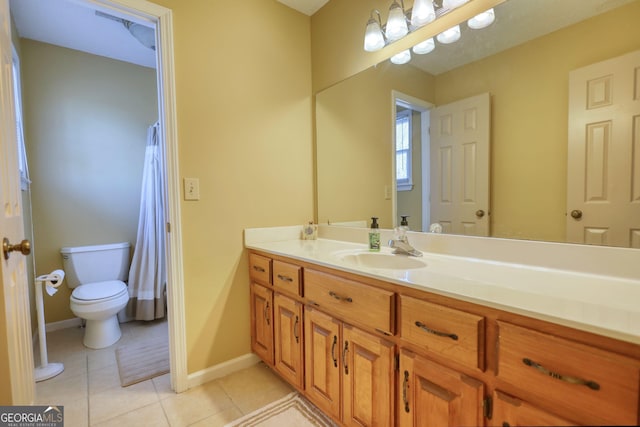 bathroom with toilet, vanity, baseboards, and tile patterned floors