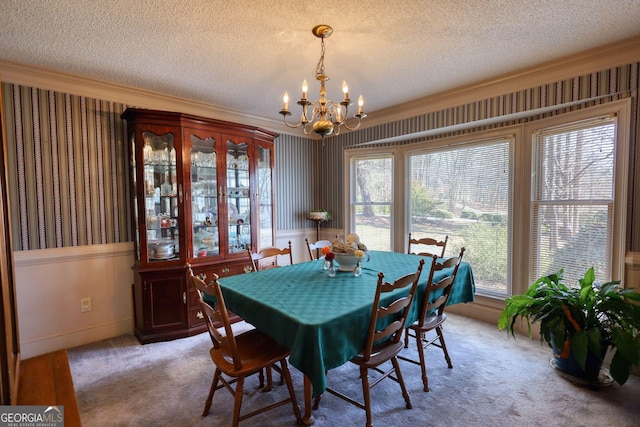 dining room with light carpet, a textured ceiling, an inviting chandelier, and wallpapered walls