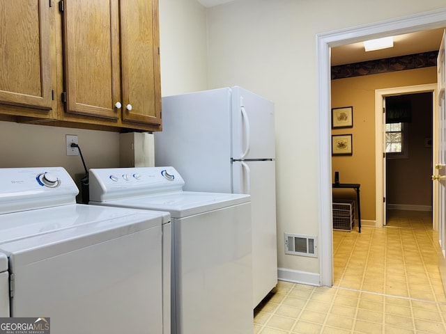 clothes washing area with cabinet space, visible vents, independent washer and dryer, and baseboards