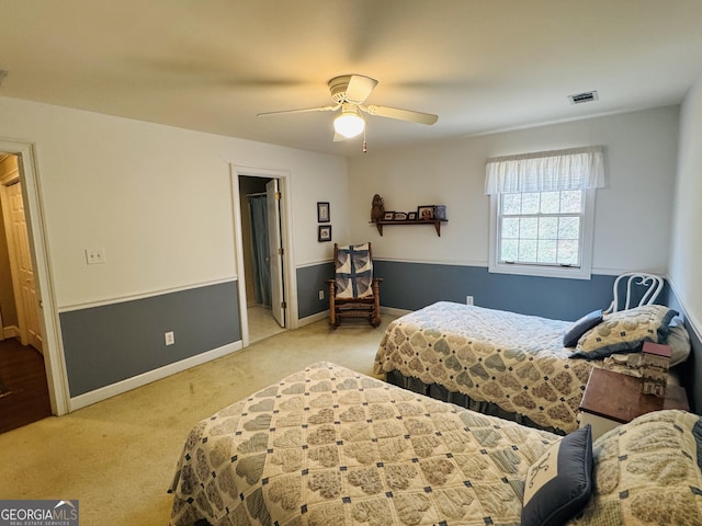 carpeted bedroom featuring visible vents, baseboards, and a ceiling fan