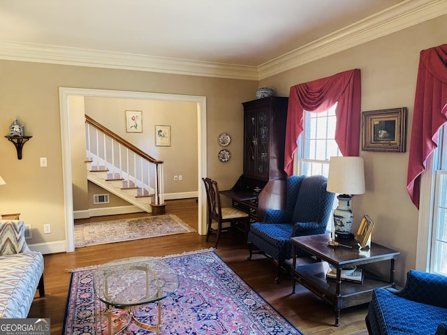 living area with stairs, ornamental molding, wood finished floors, and visible vents