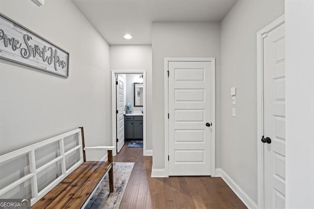 hallway featuring dark wood-style floors, baseboards, and recessed lighting