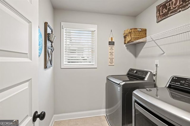 laundry room featuring laundry area, washing machine and clothes dryer, and baseboards