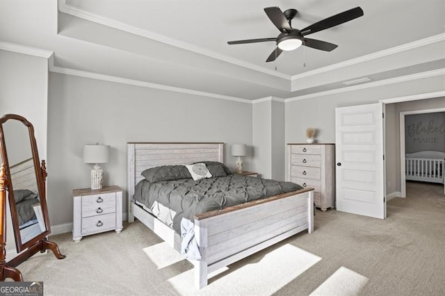 carpeted bedroom featuring baseboards, ceiling fan, a tray ceiling, and crown molding