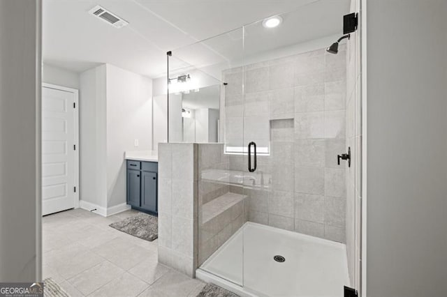 full bath with tile patterned flooring, vanity, visible vents, baseboards, and a stall shower