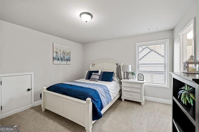 bedroom with light colored carpet, visible vents, and baseboards