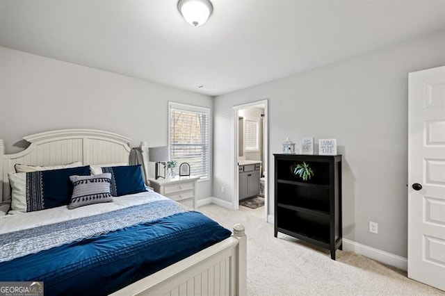 bedroom featuring light carpet, connected bathroom, and baseboards