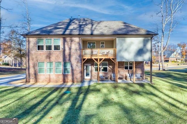 back of house featuring brick siding, a lawn, and a patio