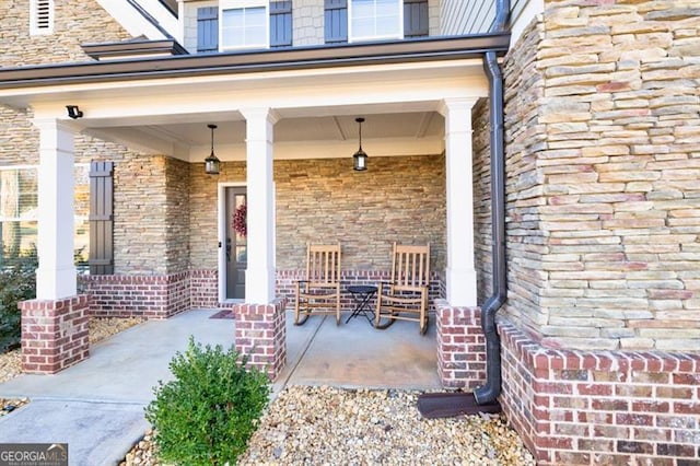 doorway to property with covered porch and brick siding