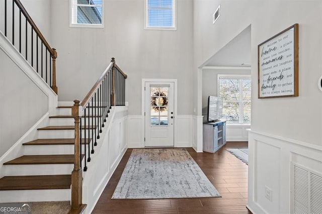 entryway featuring stairs, a wainscoted wall, dark wood finished floors, and visible vents