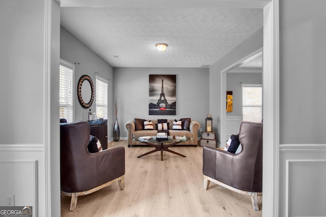 interior space featuring a textured ceiling, plenty of natural light, and wood finished floors