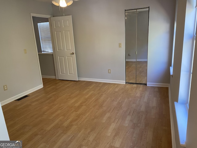 unfurnished bedroom with light wood-style flooring, visible vents, and baseboards