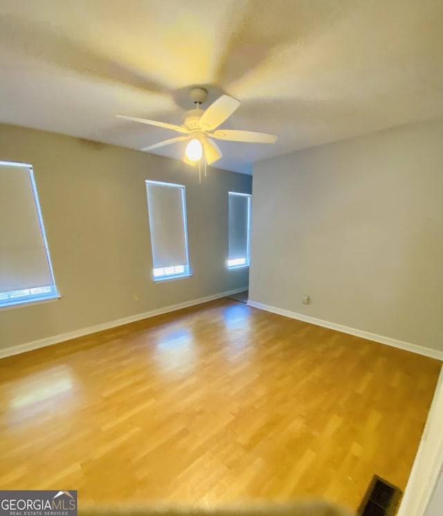 spare room featuring visible vents, light wood-style flooring, and baseboards