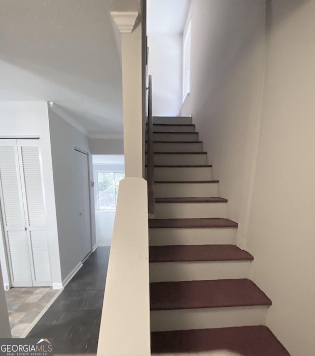 staircase featuring baseboards and ornamental molding