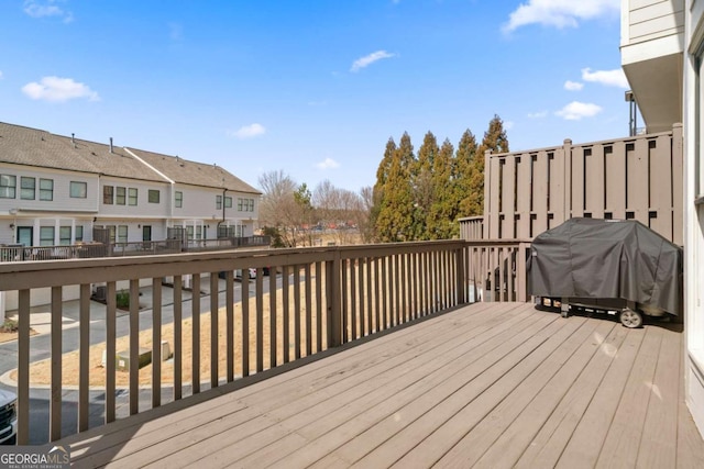 wooden terrace featuring a grill and a residential view