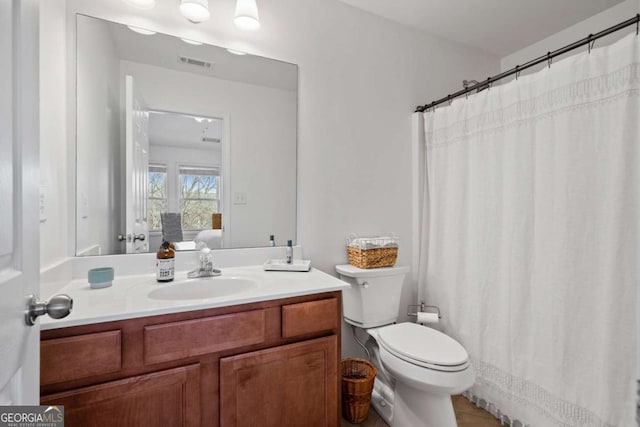 ensuite bathroom with visible vents, ensuite bath, vanity, and toilet