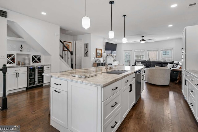 kitchen with wine cooler, visible vents, stainless steel dishwasher, open floor plan, and a sink