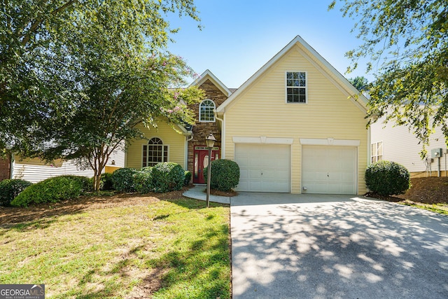 traditional-style house featuring an attached garage, concrete driveway, and a front yard