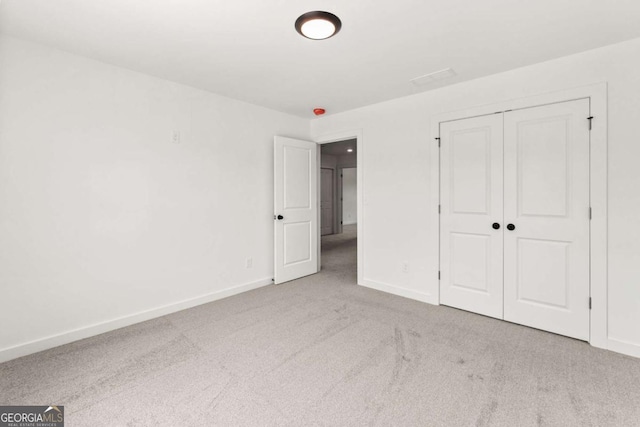 unfurnished bedroom featuring carpet, a closet, and baseboards