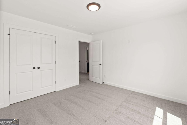 unfurnished bedroom with carpet, baseboards, and a closet