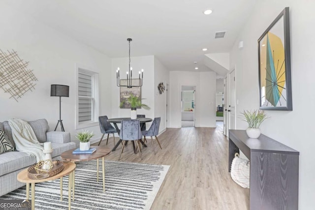 living area featuring a chandelier, recessed lighting, visible vents, and wood finished floors