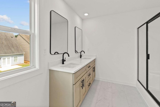 full bath with marble finish floor, plenty of natural light, and a sink