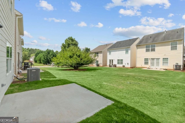 view of yard featuring central air condition unit, a patio area, and a residential view