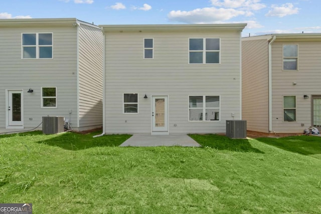 rear view of property featuring a yard, central AC unit, and a patio