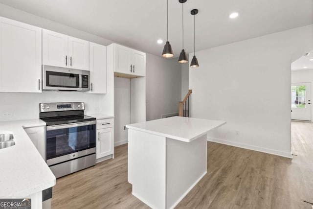 kitchen featuring light countertops, appliances with stainless steel finishes, light wood-style floors, and white cabinets