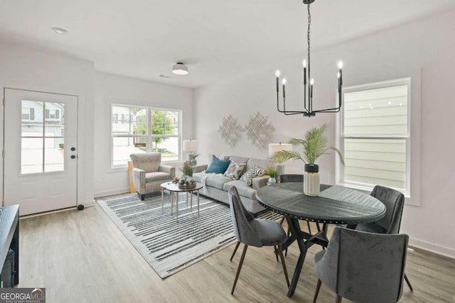 dining room featuring a notable chandelier, wood finished floors, and baseboards