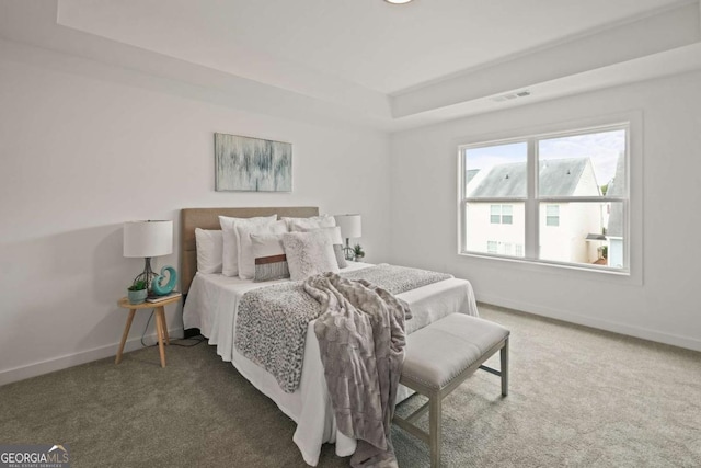 bedroom with carpet, visible vents, a raised ceiling, and baseboards