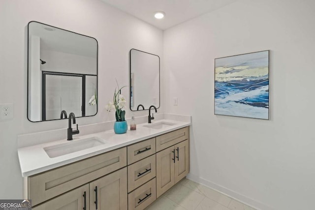 bathroom with double vanity, marble finish floor, baseboards, and a sink