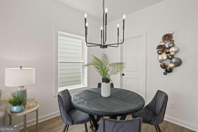 dining area featuring an inviting chandelier, baseboards, and wood finished floors