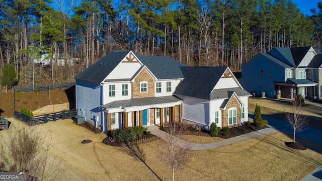 traditional-style house featuring metal roof, stone siding, and a standing seam roof