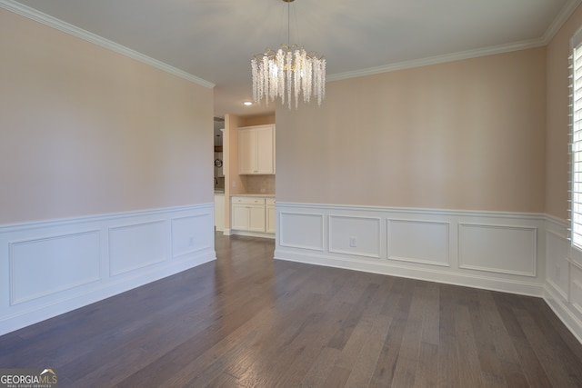 6650 Canyon Cv, Cumming, GA 30028 - unfurnished dining area featuring a chandelier, ornamental molding, a wainscoted wall, dark wood-style flooring, and a decorative wall