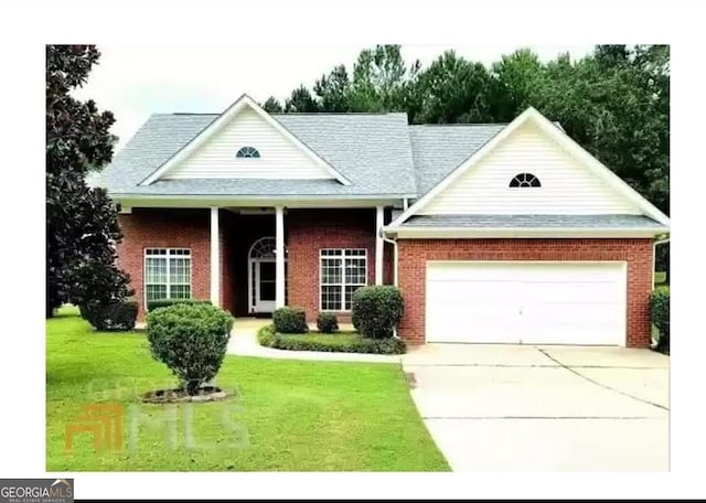 view of front of house featuring an attached garage, brick siding, driveway, and a front yard