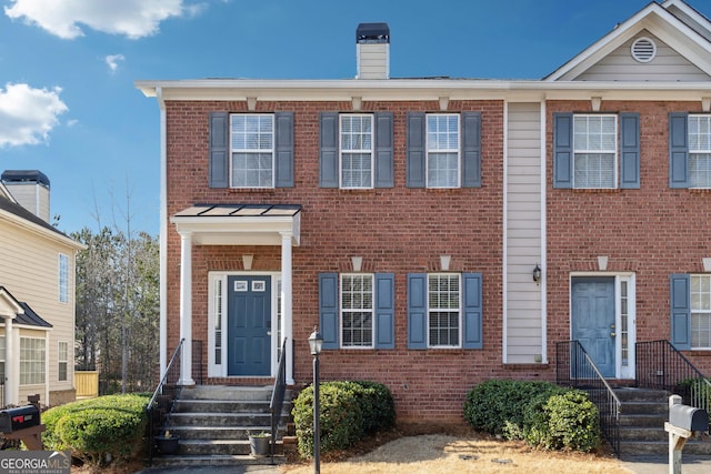 multi unit property featuring brick siding and a chimney