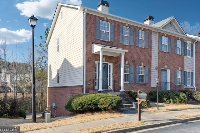 multi unit property featuring brick siding and a chimney