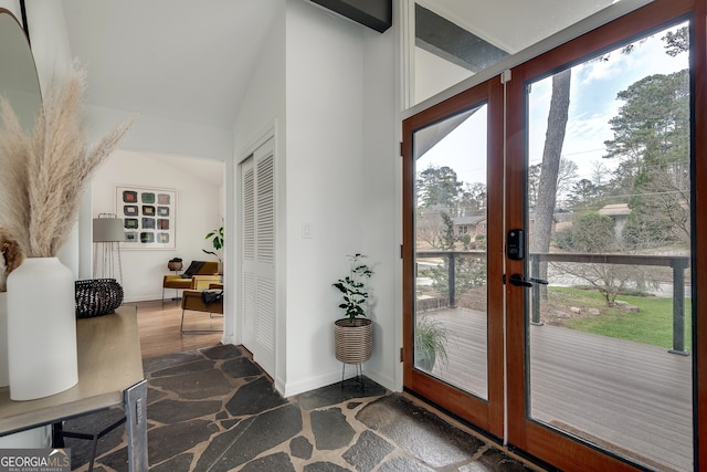 doorway to outside featuring lofted ceiling, french doors, and baseboards