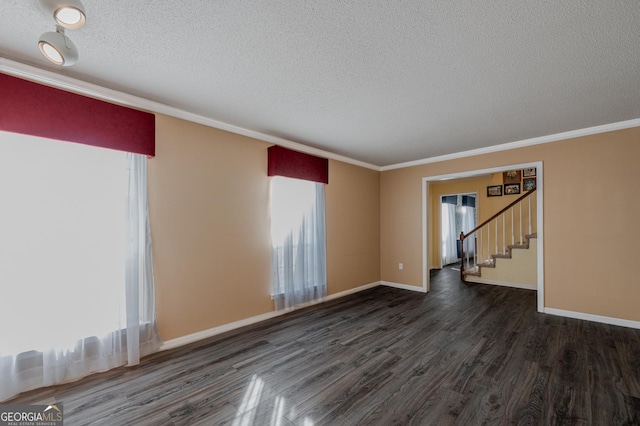 spare room with baseboards, dark wood finished floors, stairway, a textured ceiling, and crown molding