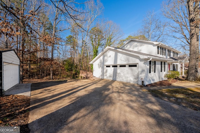 view of side of property featuring an attached garage and driveway