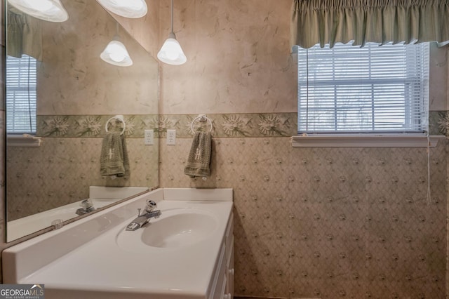 bathroom with vanity and wallpapered walls