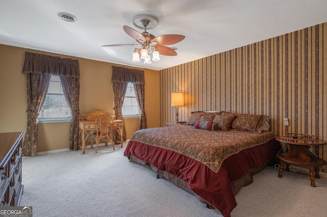 bedroom featuring carpet, visible vents, ceiling fan, baseboards, and wallpapered walls