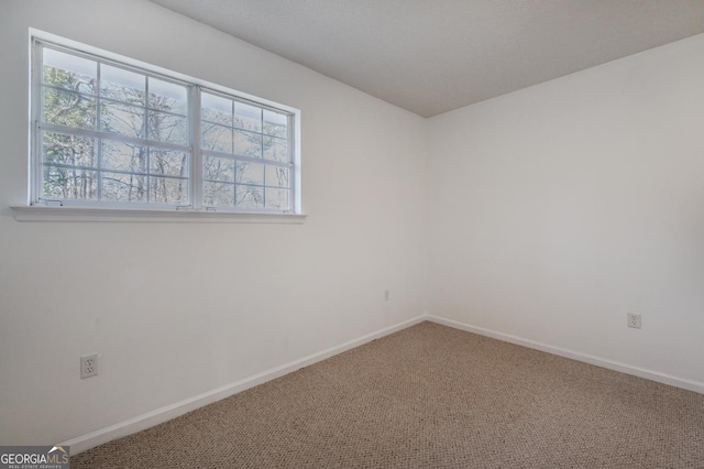 unfurnished room with baseboards, carpet flooring, and a healthy amount of sunlight