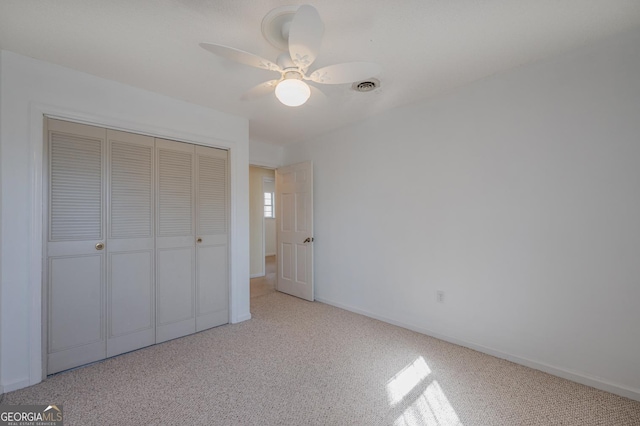 unfurnished bedroom with baseboards, visible vents, a ceiling fan, carpet, and a closet