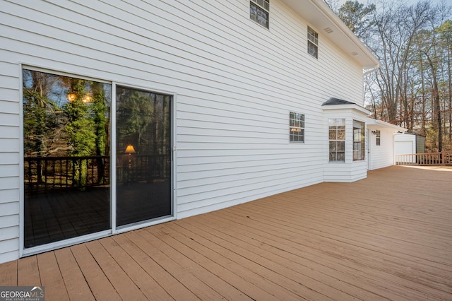 wooden deck featuring an outdoor structure and a detached garage