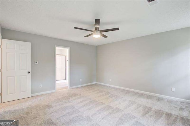 empty room featuring visible vents, baseboards, a ceiling fan, and light colored carpet