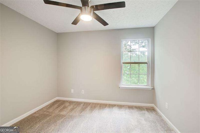 spare room featuring carpet, ceiling fan, a textured ceiling, and baseboards